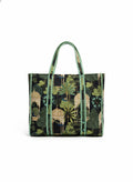 Tote bag with green leaf and castle pattern on a black background.
